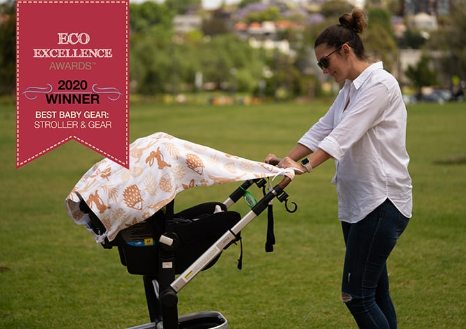 mother pushing pram with musluv sun cover shading the pram. Eco excellence award banner as overlay on image.