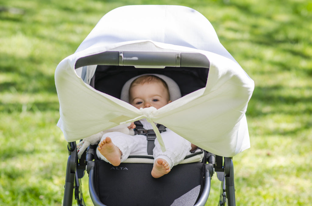 Baby in a pram with musluv baby sun shade cover and ventilation gaps